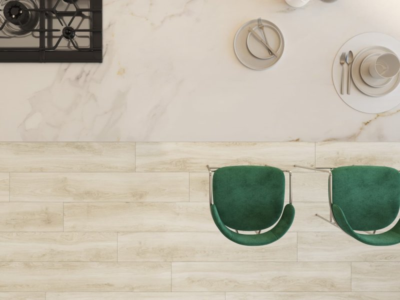 Bovenaanzicht van een keuken met Helsinki Blanco op de vloer en groene stoelen.